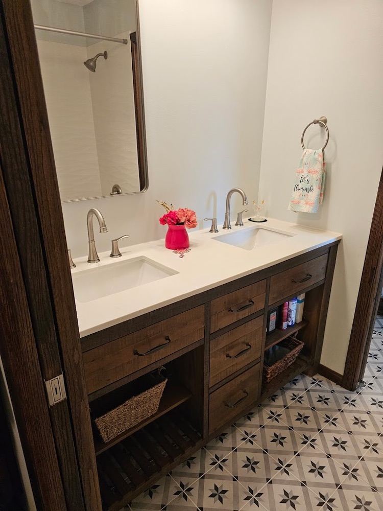 Dark wood double vanity with white quartz top and patterned tile floor